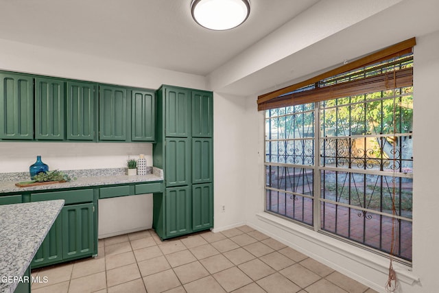 kitchen featuring light tile patterned flooring, green cabinets, and a wealth of natural light