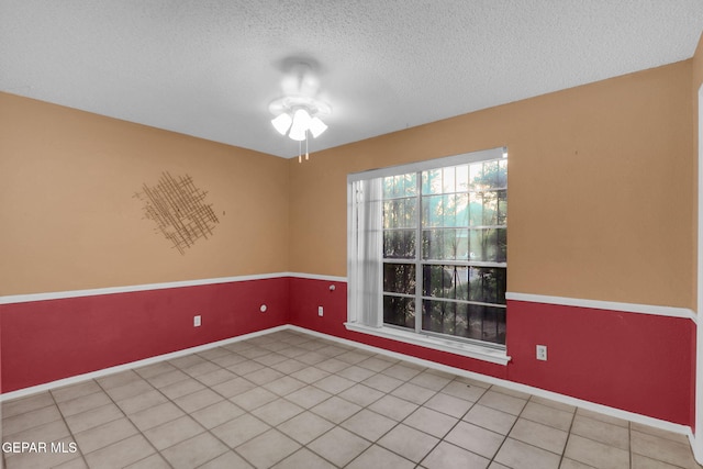 tiled empty room featuring a textured ceiling and ceiling fan