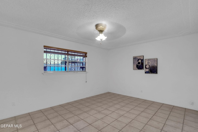 spare room featuring ceiling fan, a textured ceiling, and light tile patterned flooring