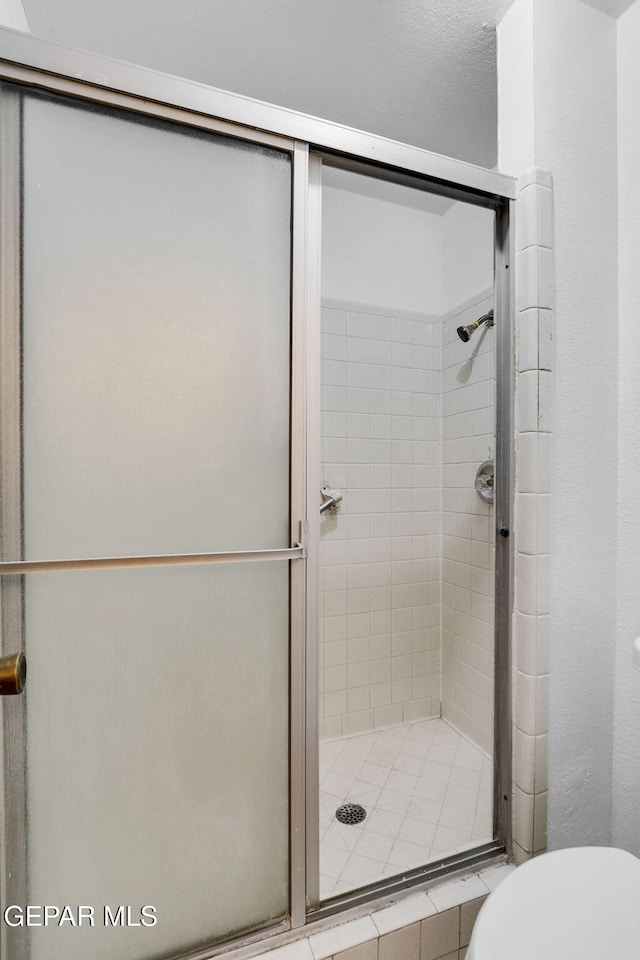 bathroom with toilet and an enclosed shower