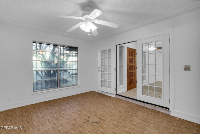 empty room with a textured ceiling, light parquet flooring, and ceiling fan