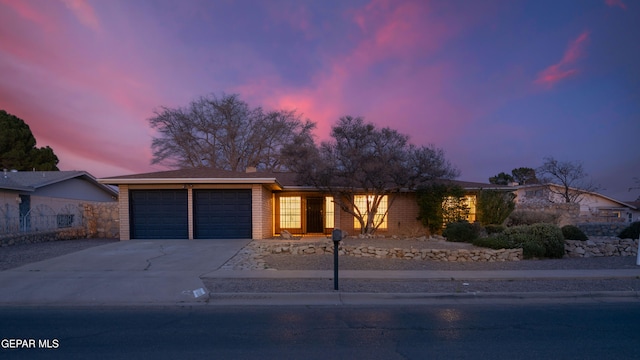 view of front of property featuring concrete driveway, brick siding, and an attached garage