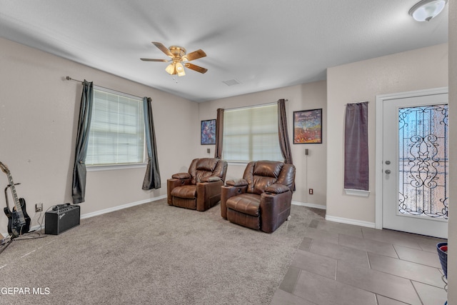 living area with ceiling fan and light tile patterned flooring