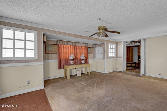 unfurnished living room featuring crown molding, a textured ceiling, carpet flooring, and ceiling fan