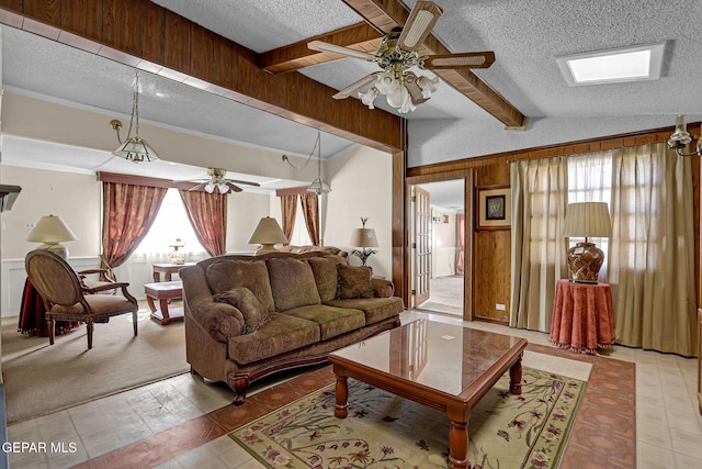 living room with wooden walls, lofted ceiling with beams, a textured ceiling, and ceiling fan