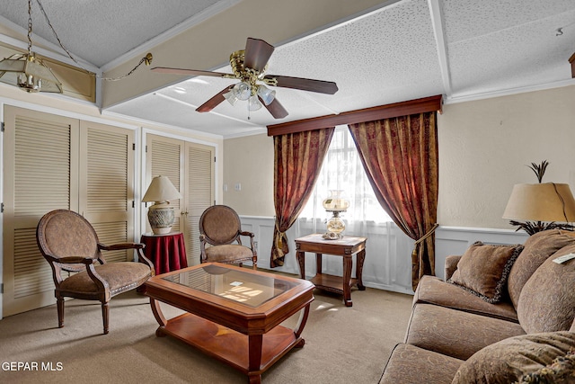 carpeted living room with crown molding, a textured ceiling, and ceiling fan