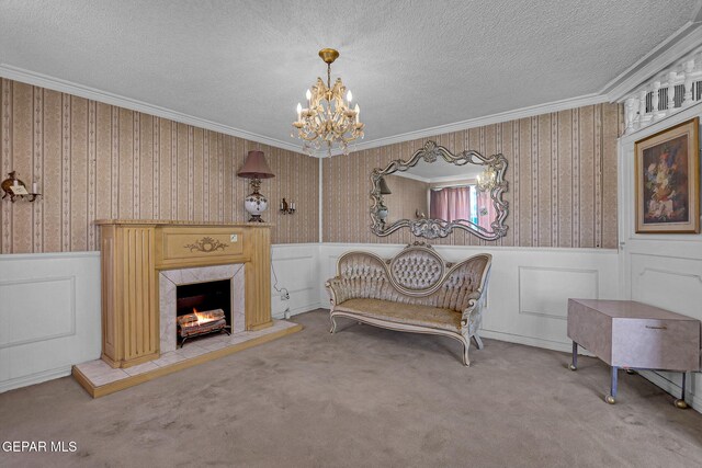 sitting room with crown molding, carpet floors, a chandelier, and a fireplace