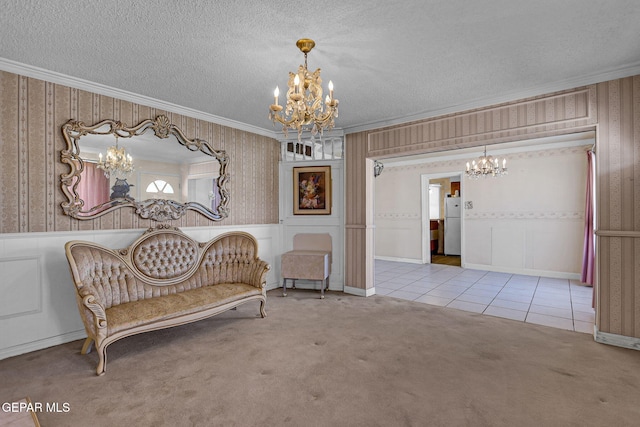 sitting room with ornamental molding, a textured ceiling, a notable chandelier, and light colored carpet