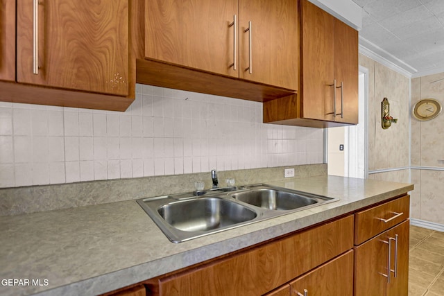 kitchen featuring light tile patterned flooring, crown molding, and sink