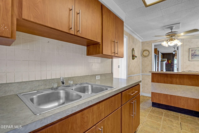 kitchen with tile patterned floors, ornamental molding, sink, ceiling fan, and tasteful backsplash