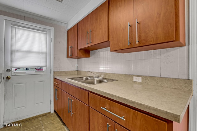 kitchen featuring sink, light tile patterned flooring, and crown molding