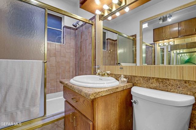 bathroom featuring vanity, toilet, and a shower with shower door