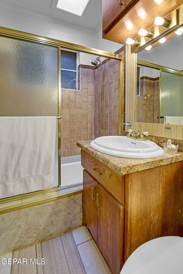 full bathroom featuring vanity, toilet, tile patterned floors, and bath / shower combo with glass door