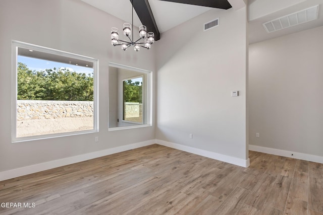 empty room featuring visible vents, light wood finished floors, baseboards, and a notable chandelier