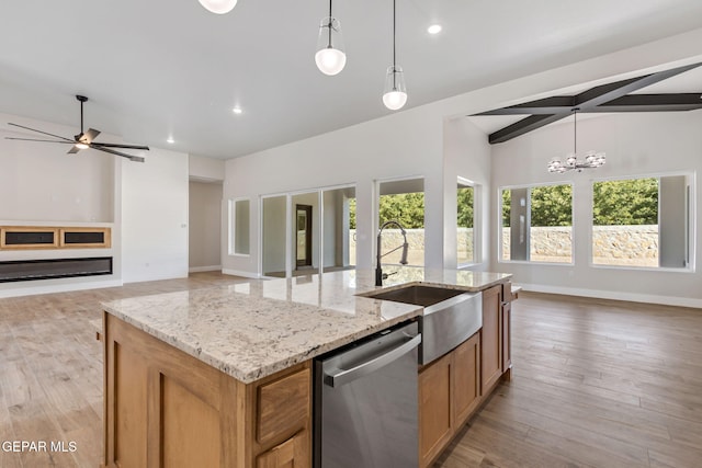 kitchen with a sink, a kitchen island with sink, dishwasher, and open floor plan