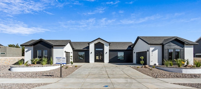 view of front of property featuring an attached garage, driveway, and stucco siding