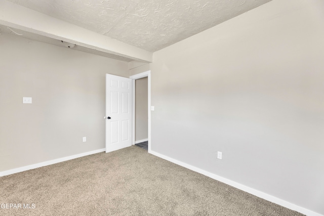 carpeted empty room with a textured ceiling