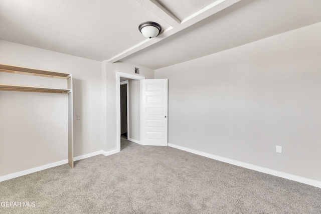 unfurnished bedroom with a closet, carpet flooring, and a textured ceiling