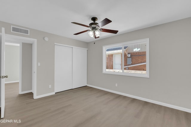 unfurnished bedroom with a closet, light hardwood / wood-style floors, and ceiling fan