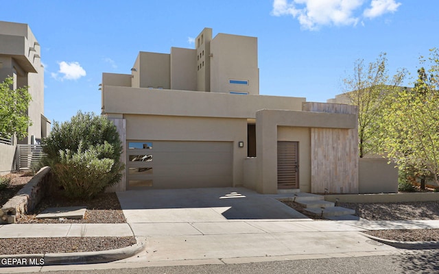 pueblo-style house featuring a garage