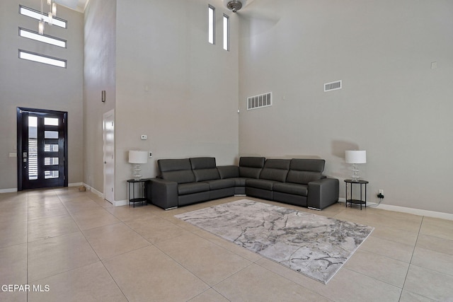 living room featuring a towering ceiling and light tile patterned floors