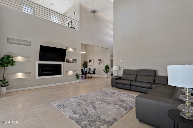 living room with a high ceiling and light tile patterned floors