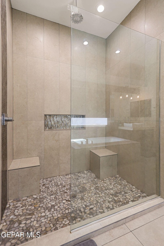 bathroom with tile patterned floors and tiled shower