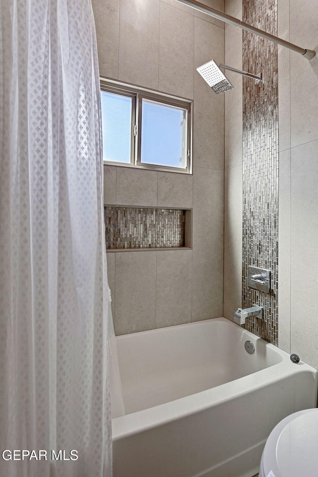 bathroom featuring shower / bath combo with shower curtain and toilet