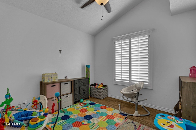 rec room featuring hardwood / wood-style floors, ceiling fan, a textured ceiling, and vaulted ceiling