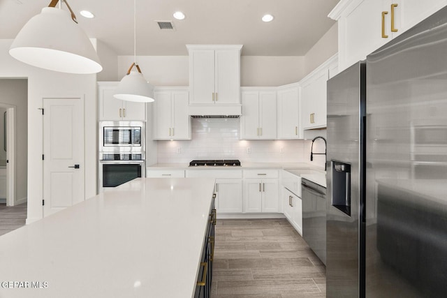 13397 Highworth Dr, El Paso, TX 79928 - kitchen with visible vents, light countertops, white cabinets, backsplash, and stainless steel appliances