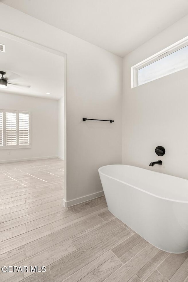 13397 Highworth Dr, El Paso, TX 79928 - full bathroom featuring a ceiling fan, baseboards, a freestanding tub, wood finished floors, and visible vents