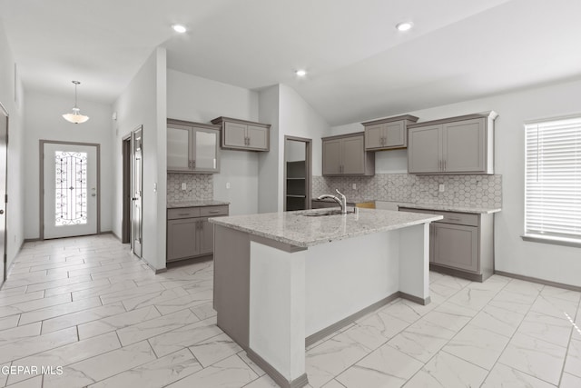 1229 Night Sky St, El Paso, TX 79928 - kitchen featuring light marble finish flooring, gray cabinetry, a sink, a center island with sink, and backsplash