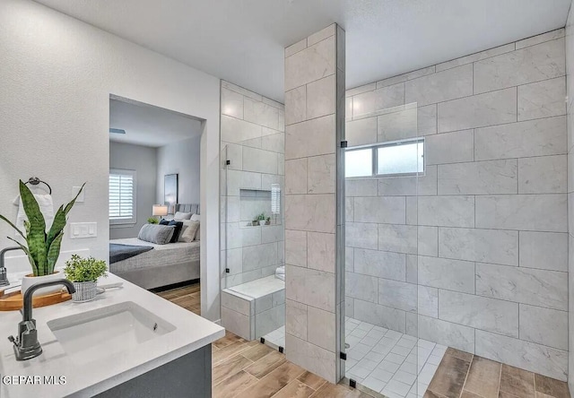 bathroom featuring vanity, hardwood / wood-style floors, and a tile shower