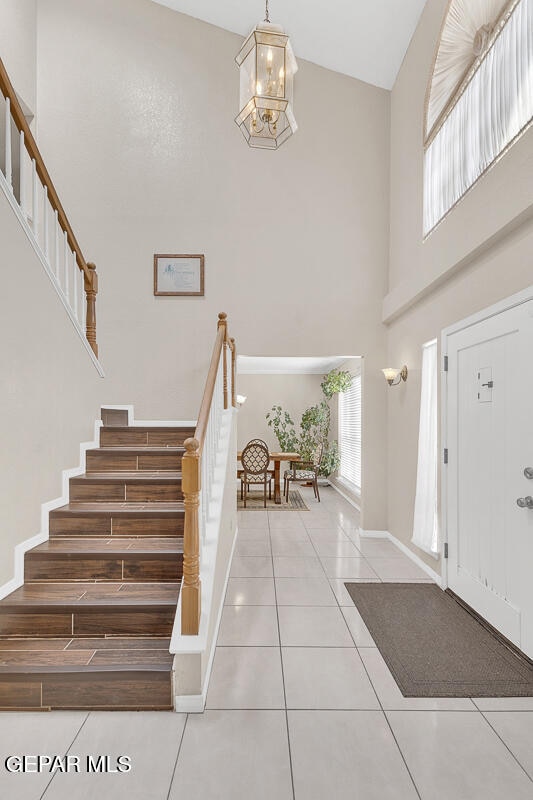 foyer featuring a chandelier, high vaulted ceiling, and tile patterned floors