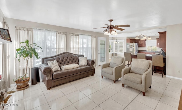 living room with light tile patterned flooring and ceiling fan with notable chandelier