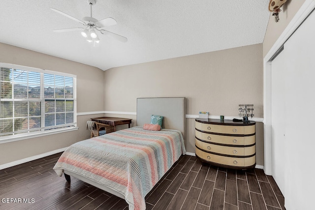 bedroom featuring a closet, dark hardwood / wood-style floors, a textured ceiling, and ceiling fan