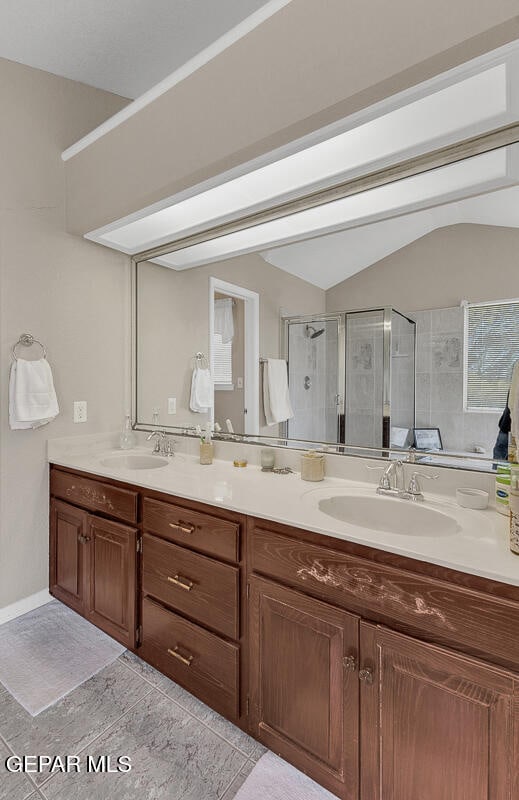 bathroom with vanity, walk in shower, and vaulted ceiling