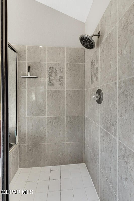 bathroom with a tile shower and vaulted ceiling