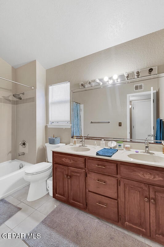 full bathroom with tiled shower / bath, vanity, toilet, and tile patterned floors