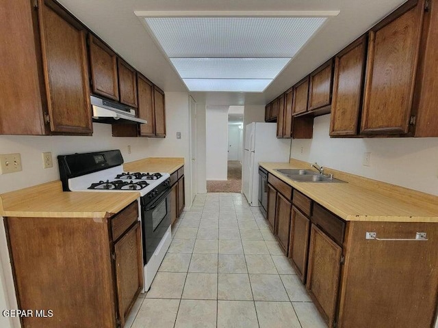 kitchen featuring black dishwasher, sink, white gas range, and light tile patterned floors