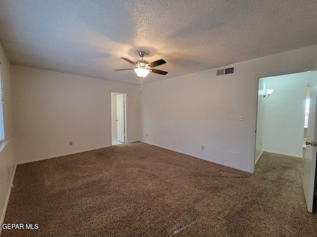 carpeted empty room with ceiling fan and a textured ceiling