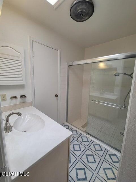 bathroom with vanity, tile patterned flooring, and a shower with door