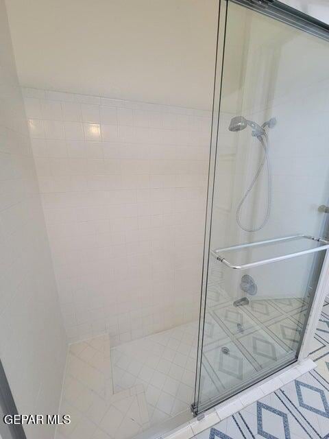 bathroom featuring walk in shower and tile patterned flooring