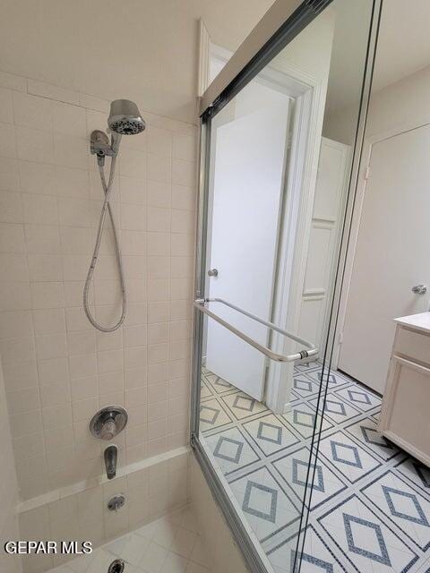 bathroom with vanity, tile patterned flooring, and bath / shower combo with glass door