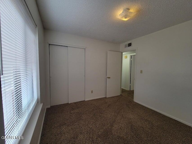 unfurnished bedroom featuring multiple windows, a closet, and carpet flooring