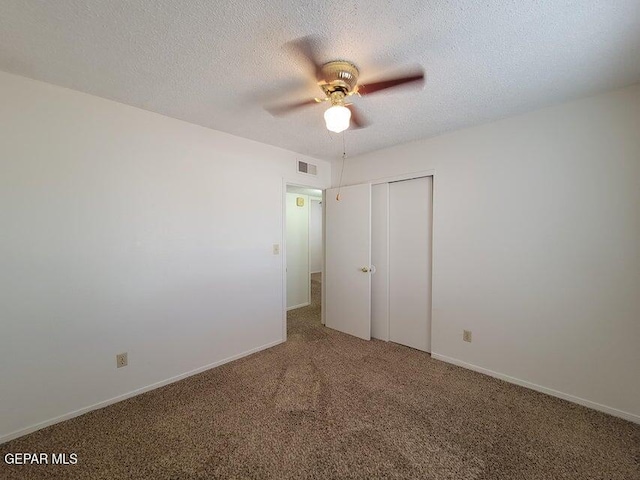 unfurnished bedroom with carpet flooring, a textured ceiling, a closet, and ceiling fan