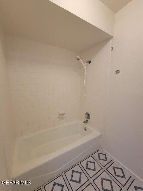 bathroom with tiled shower / bath and tile patterned flooring