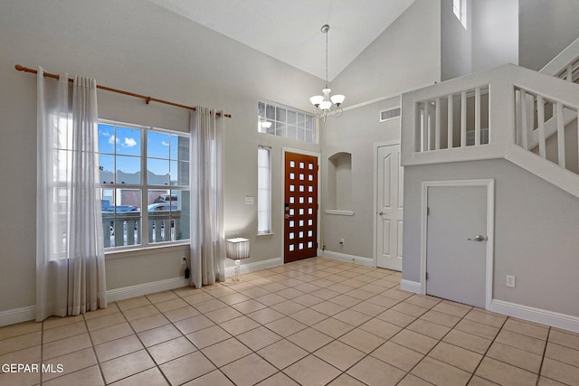 tiled foyer featuring a notable chandelier, a textured ceiling, and high vaulted ceiling