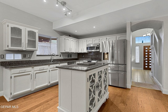 kitchen with a kitchen island, light hardwood / wood-style flooring, stainless steel appliances, and white cabinets