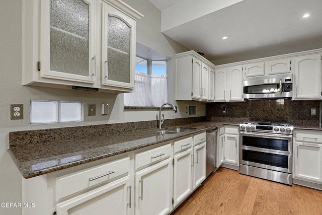 kitchen featuring white cabinets, stainless steel appliances, sink, and light wood-type flooring